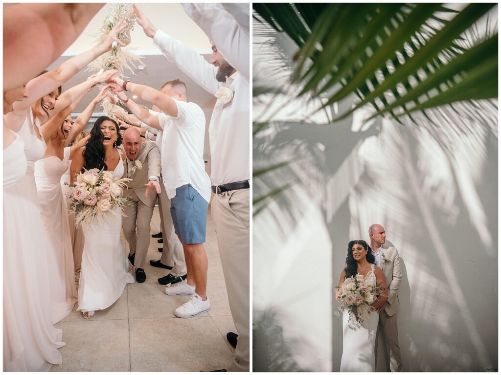 bride and groom posing in front of white wall with green palm leaves in foreground