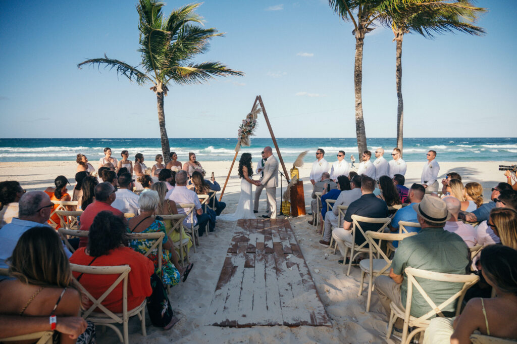 wedding ceremony on beach with triangular ceremony arch at hard rock punta cana resort