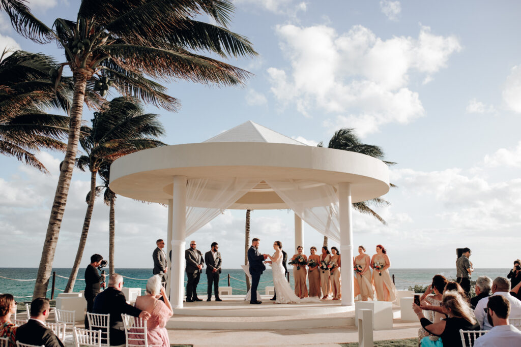 wedding ceremony under white gazebo in front of ocean at hyatt ziva cancun