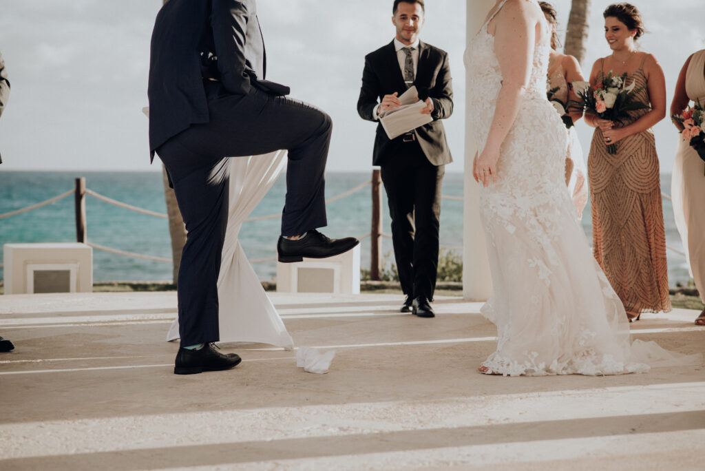 groom stomping on white cloth containing a piece of glass during jewish wedding ceremony 