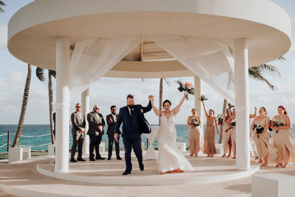 bride and groom cheering at the end of their wedding ceremony at hyatt ziva cancun