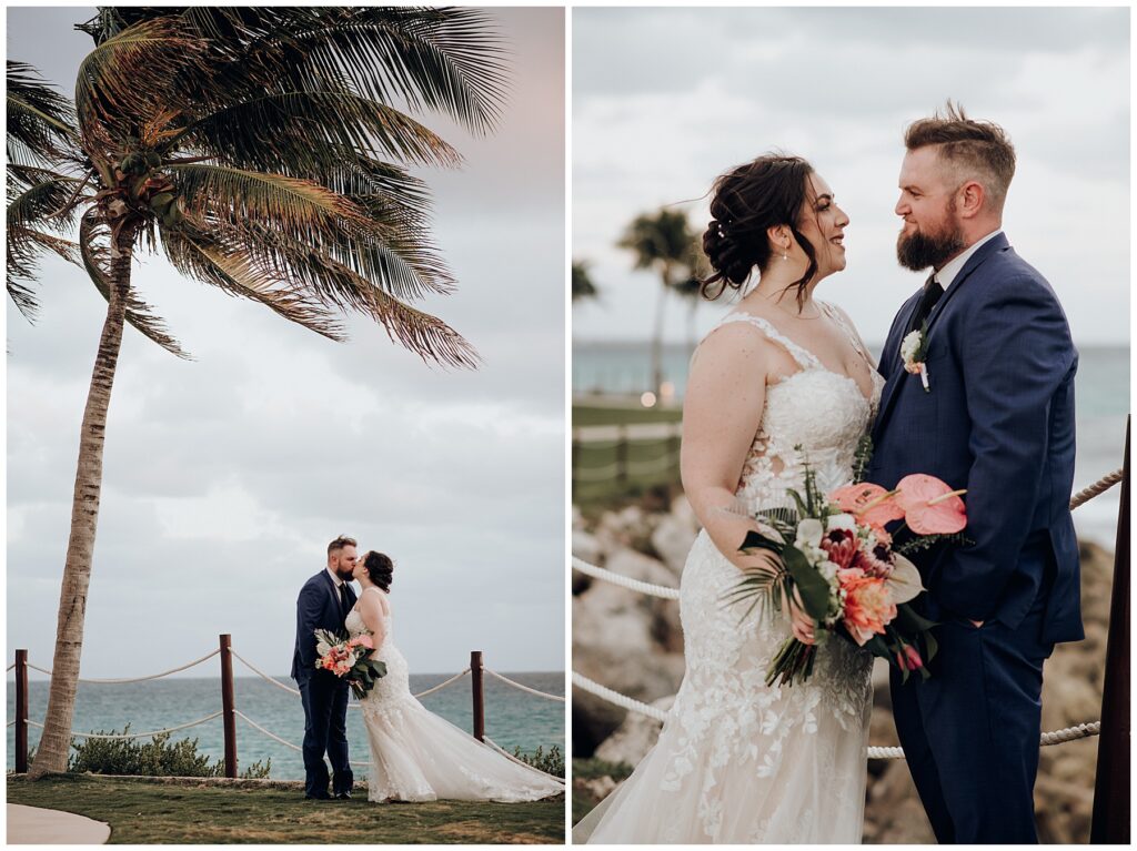 bride and groom kissing under palm tree with strong winds and ocean in background 