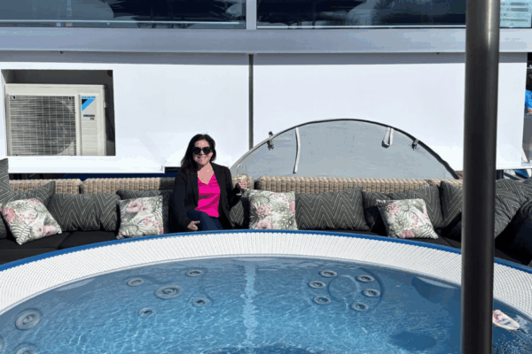 A European river cruise specialist relaxing on the deck of an AmaWaterways Rhine River cruise with a glass of wine.
