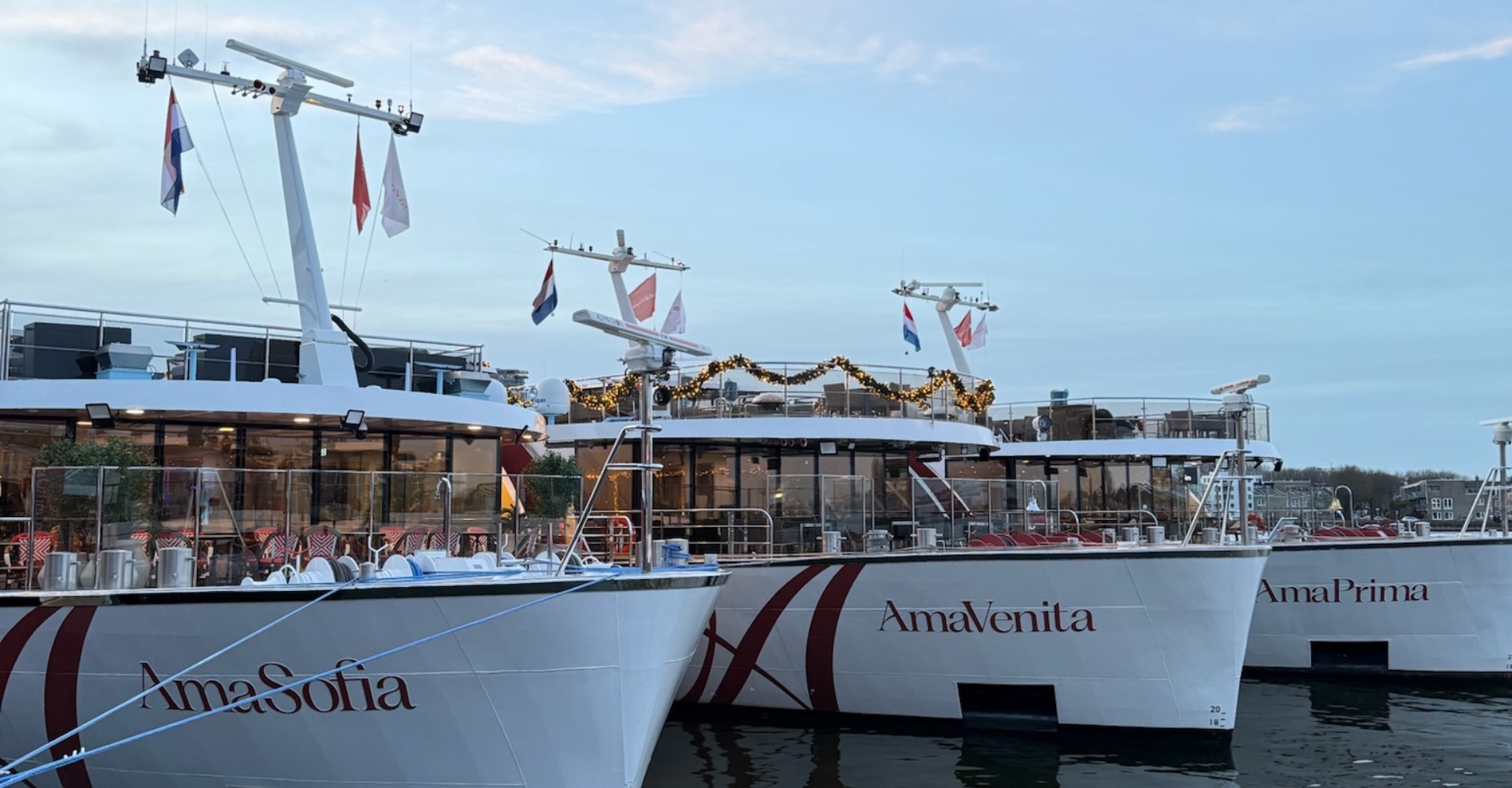 Three AmaWaterways ships at a river cruise expo in Amsterdam, showcasing one of the best river cruise lines and top river cruise companies in Europe.