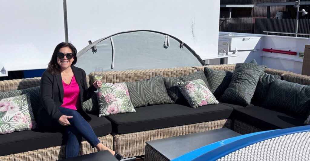 Lauren Doyle enjoying a Rhine River wine cruise in comfortable yet elevated river cruise attire featuring jeans, a blazer, and stylish layering pieces.